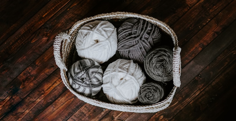 white and brown yarn in basket e