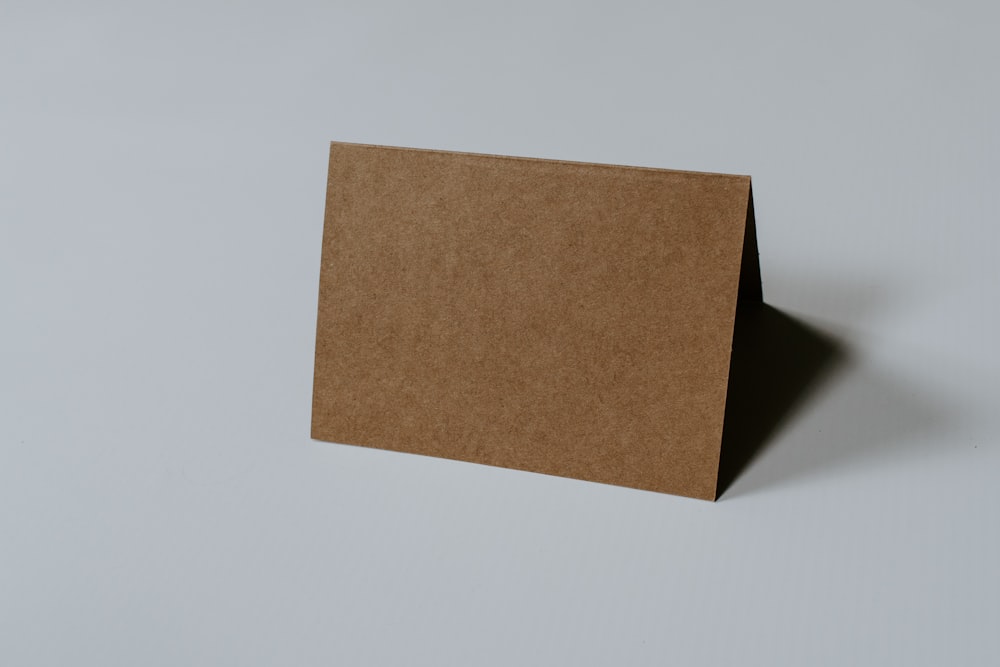 Libro de tapa dura marrón sobre superficie blanca