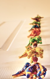 Rows of elephant-patterned apparel hanging against a backdrop of ancient trees.