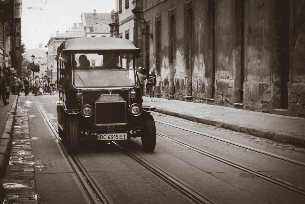 vintage black vehicle on road near building at daytime