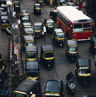 black-and-yellow auto rickshaw on road