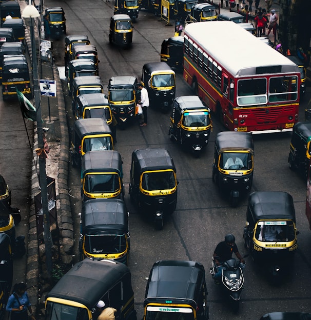 black-and-yellow auto rickshaw on road