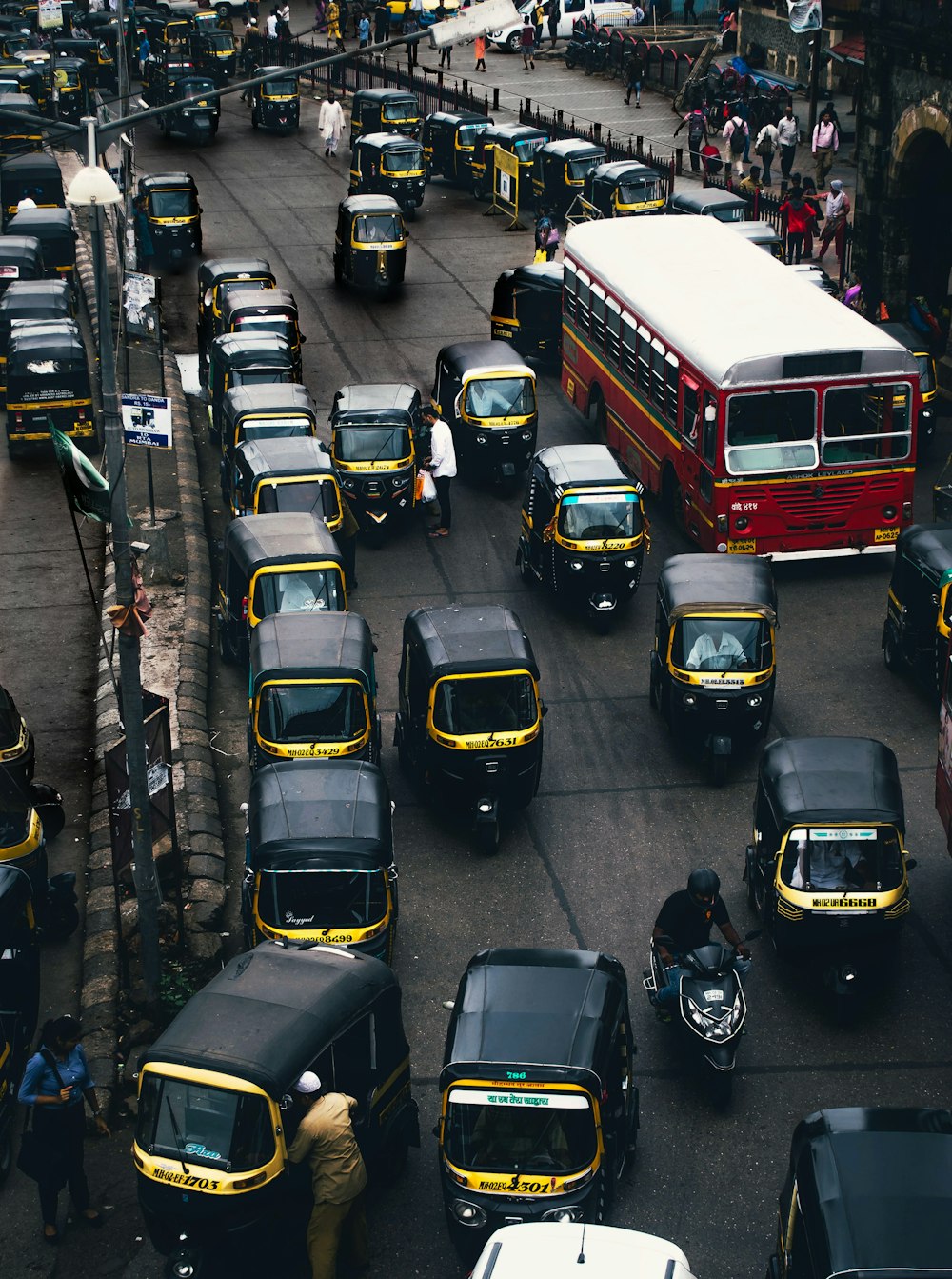 black-and-yellow auto rickshaw on road