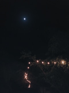 A cozy night scene featuring a person wearing a moon-themed shirt under a starry sky.