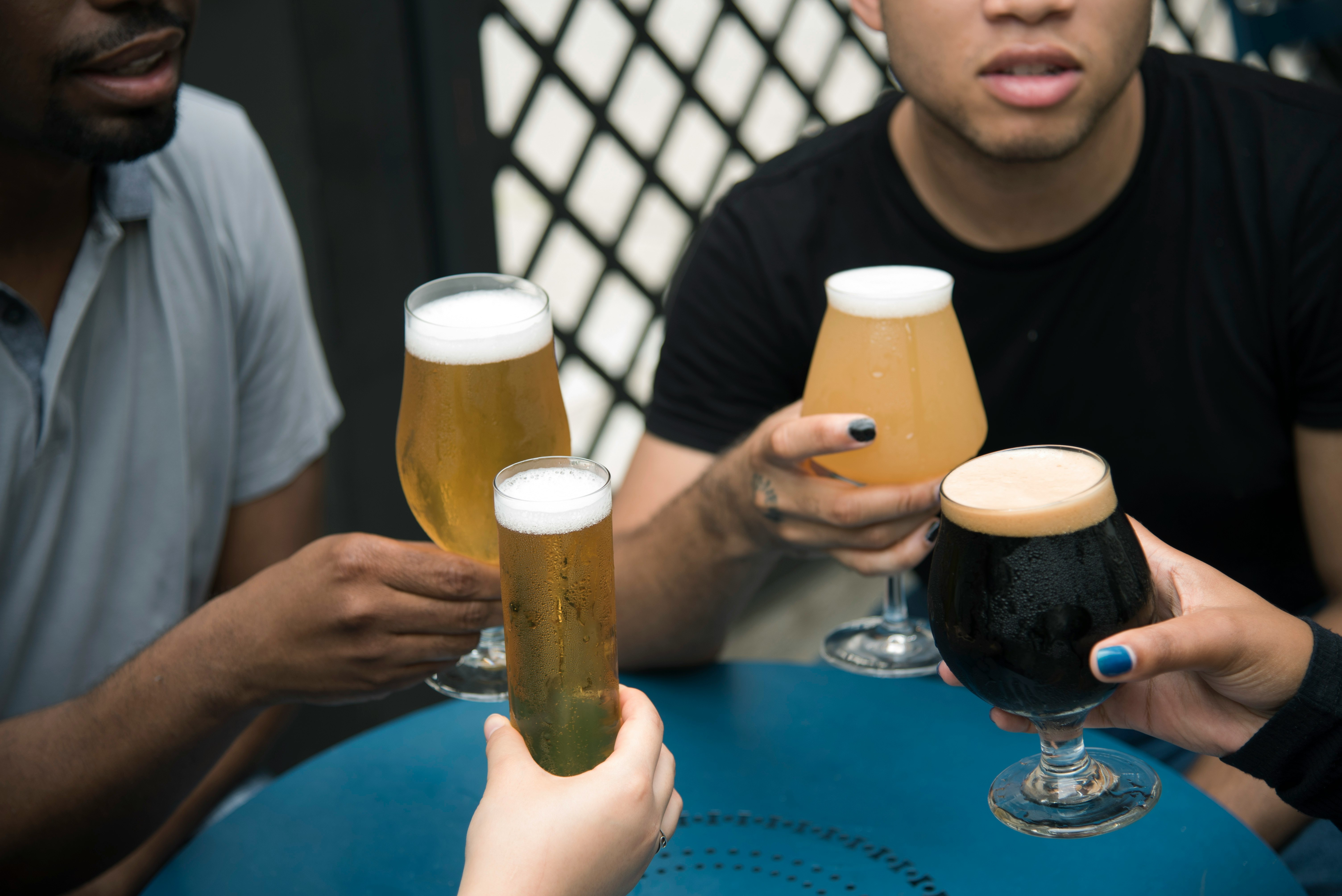 four person holding glass goblets