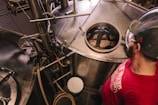 man standing beside stainless steel industrial machinery