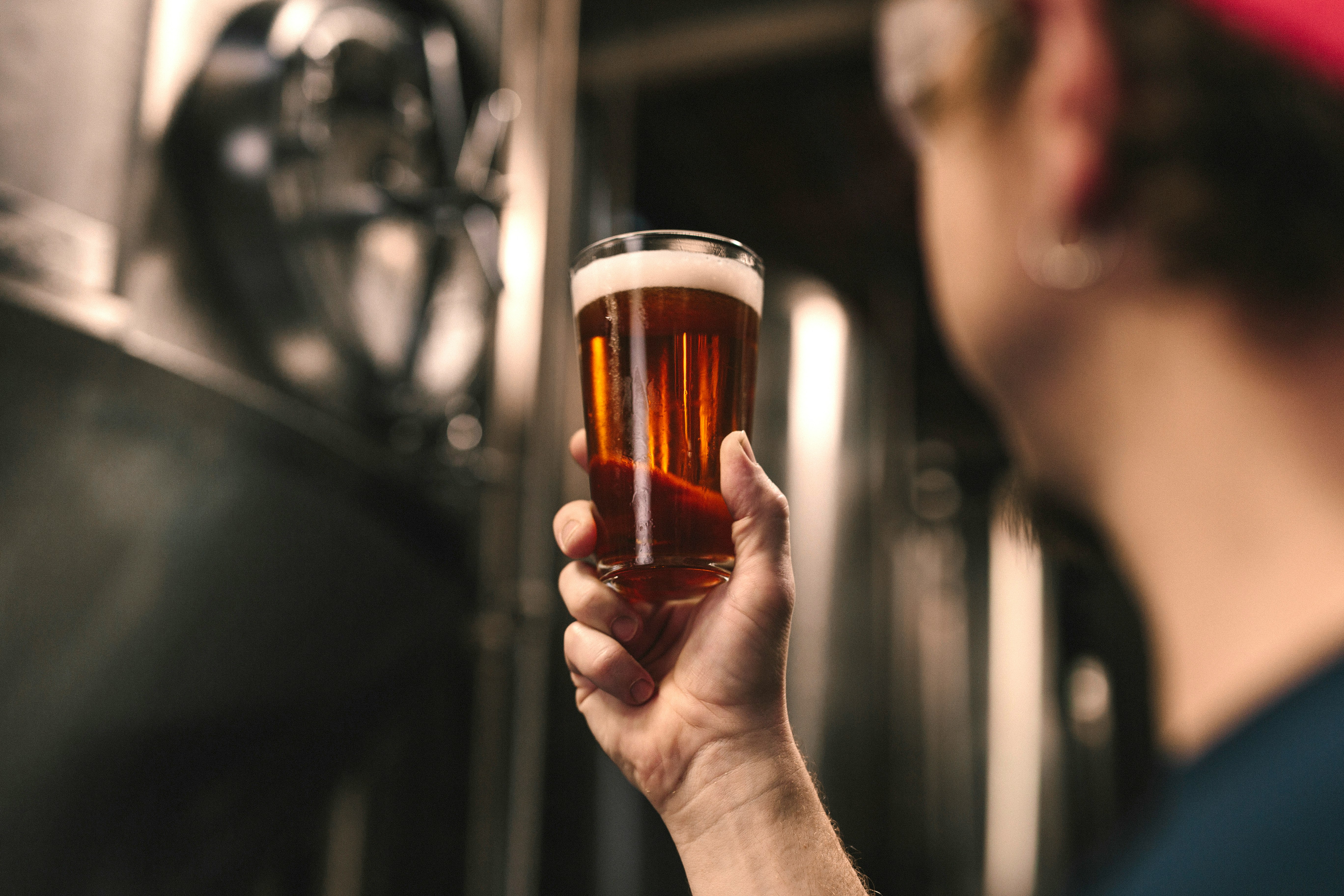 selective focus photography of person holding clear drinking glass