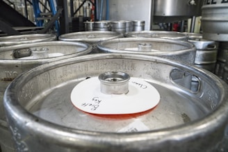 Photo of a modern production line assembling stainless steel beer kegs in a clean factory environment