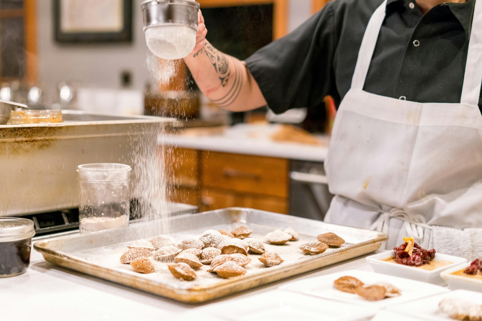 Restaurant chef dusting sugar on pastries in the style of Willy Wonka.