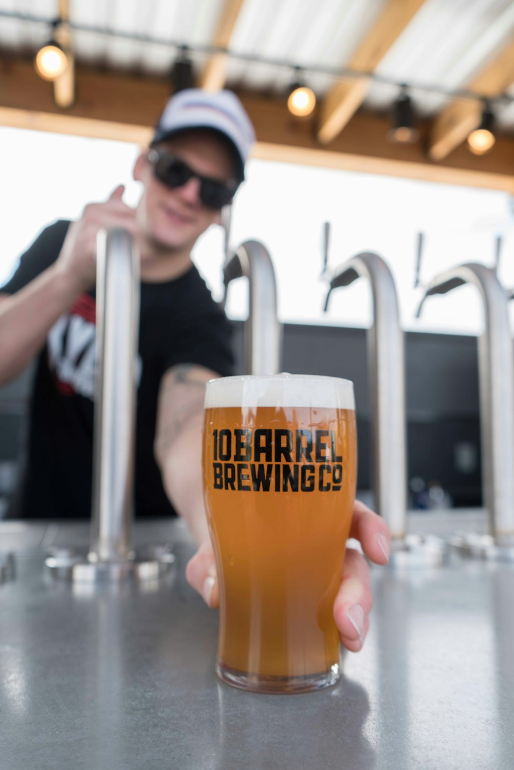 person holding 10 Barrel Brewing Co.-printed pilsner glass