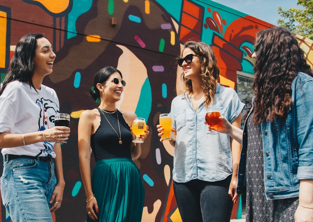 group of women standing near decorated wall