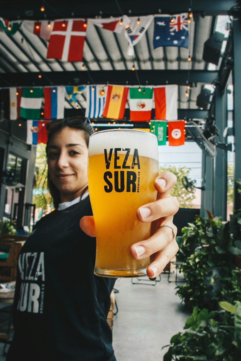 filtered photography of woman holding beer-filled Veza Suri pilsener glass