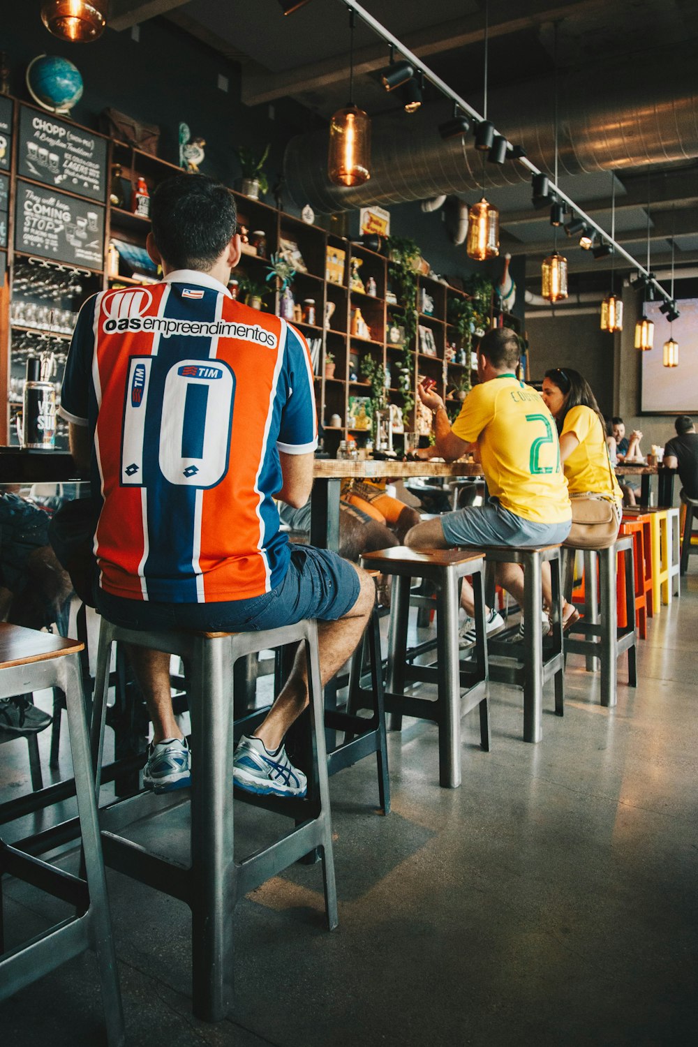 homme assis sur des tabourets de bar