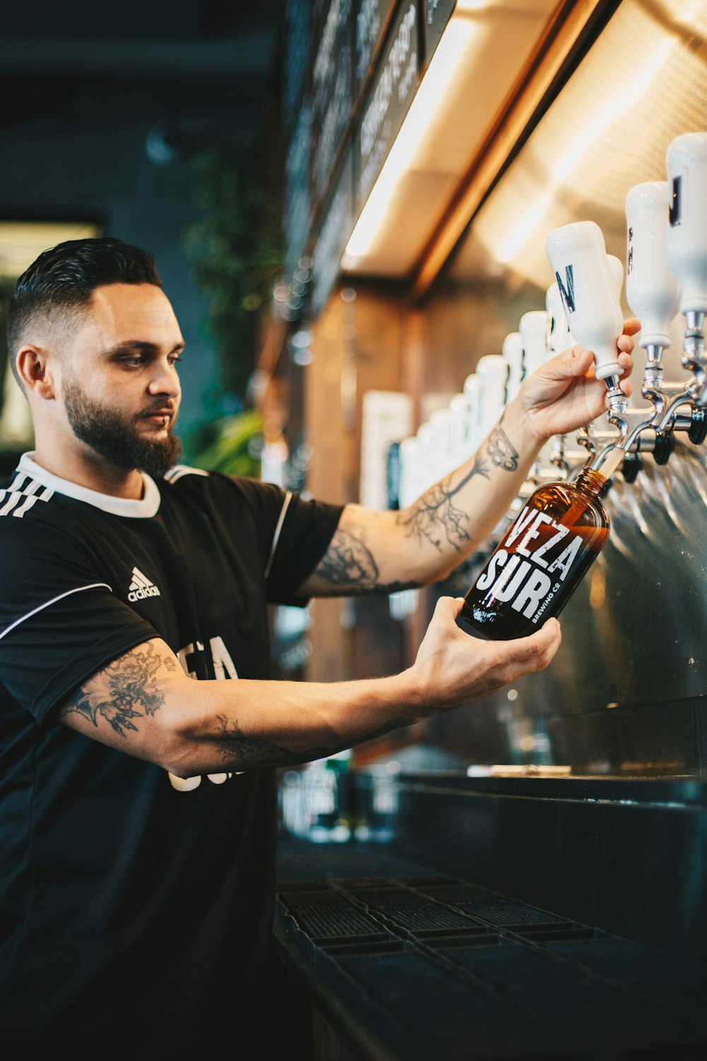 man pouring liquid on bottle