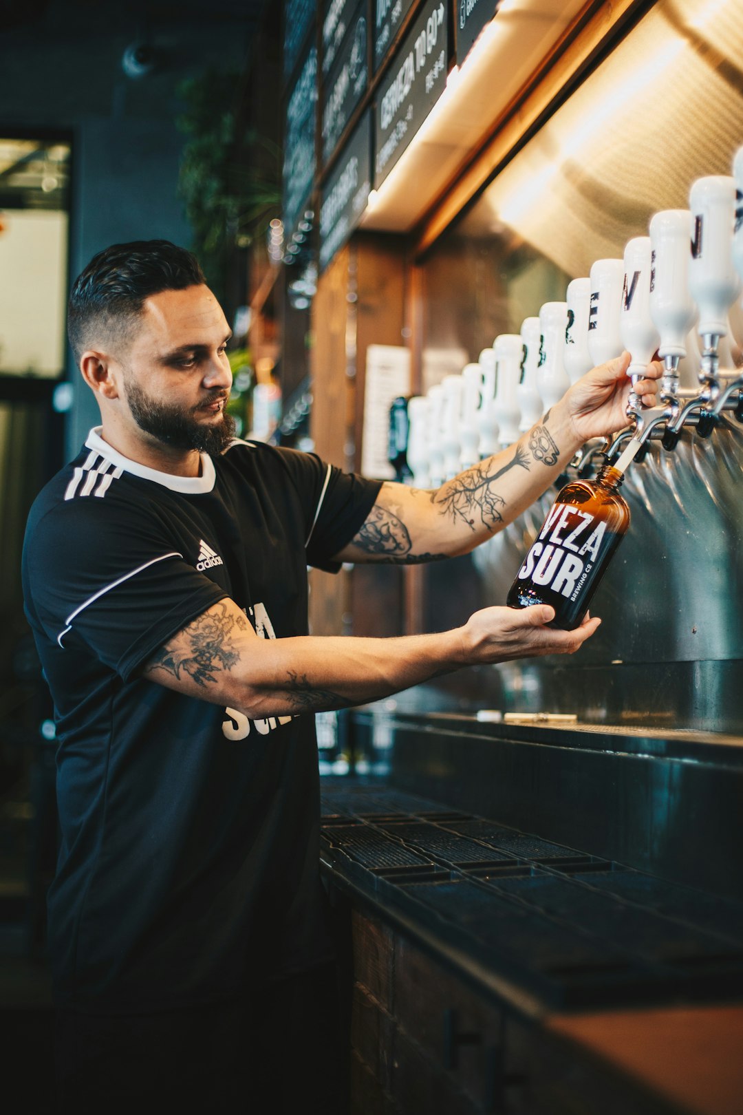 shallow focus photography of man refilling bottle