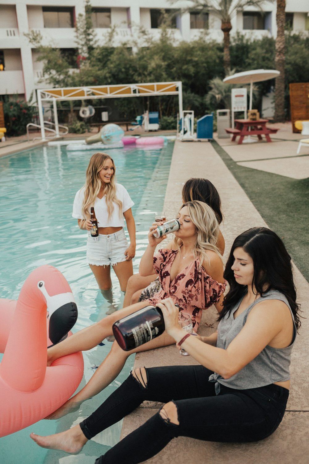 gruppo di donne che si siedono vicino alla piscina