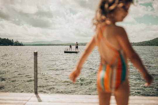 selective focus photography of two person standing on platform on body of water in Lake Winnipesaukee United States