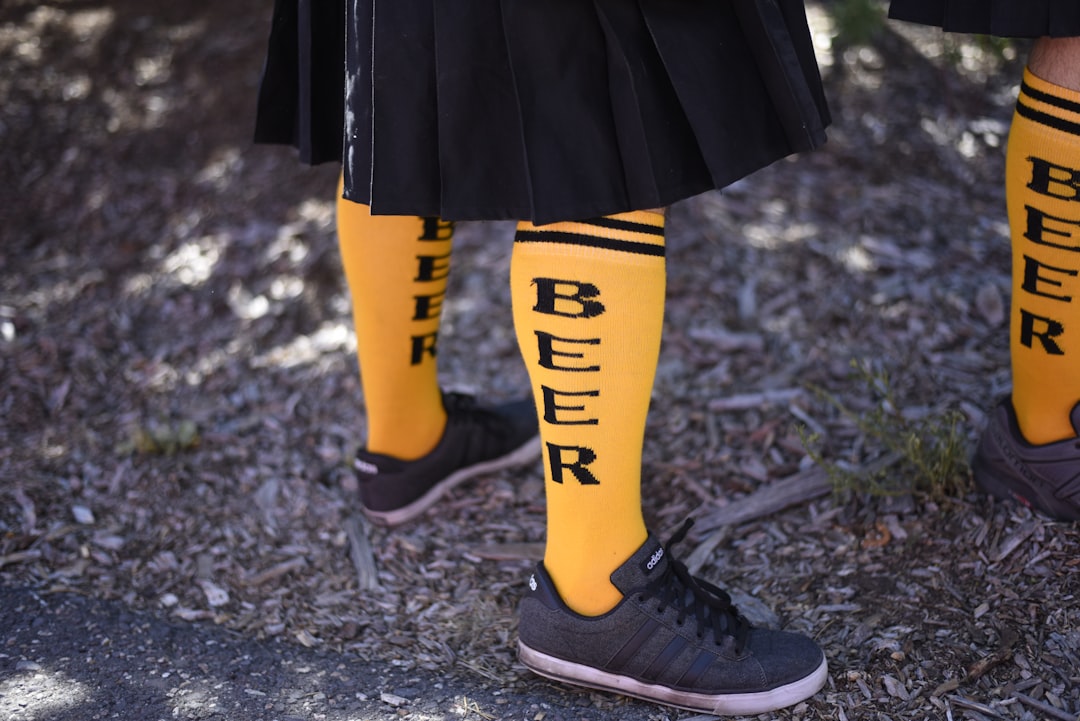 person showing pair of black low-top sneakers