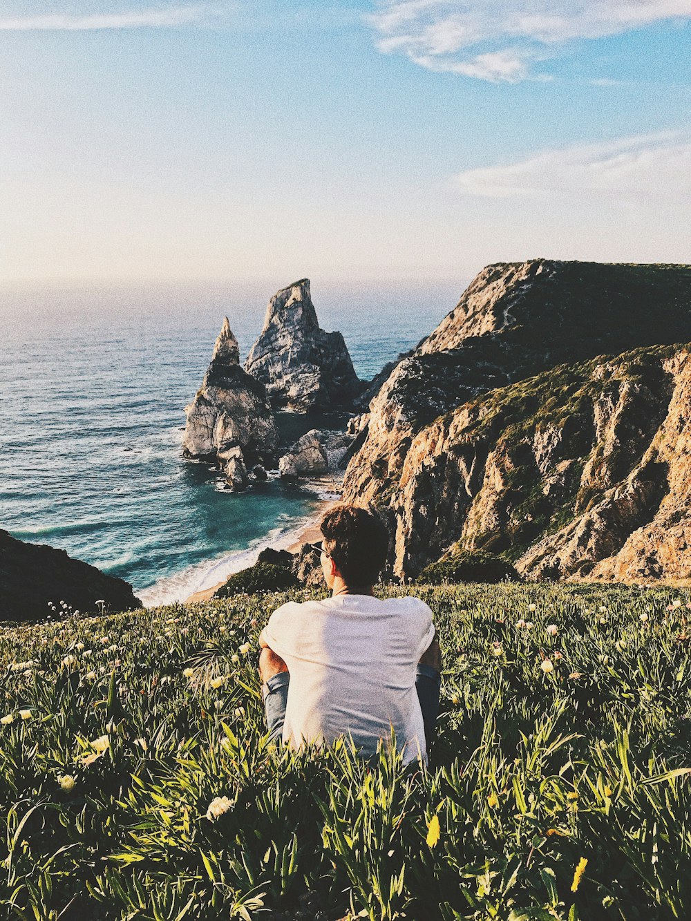 man sitting on hill top during daytime