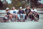 five group of men sitting together with their skateboards