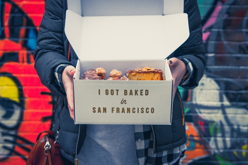 person holding cake in box