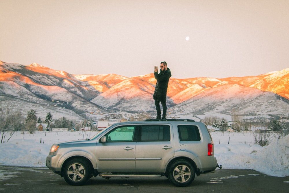 man standing on top of SUV