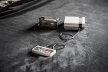 Close-up of a freshly assembled NES cartridge with custom label and shell beside programming equipment