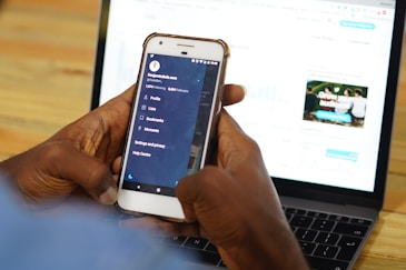 person using a laptop and smartphone