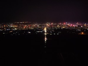 A lively cityscape at night showcasing famous landmarks illuminated with colorful lights.
