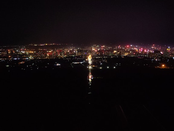 A vibrant cityscape at night, filled with illuminated buildings.