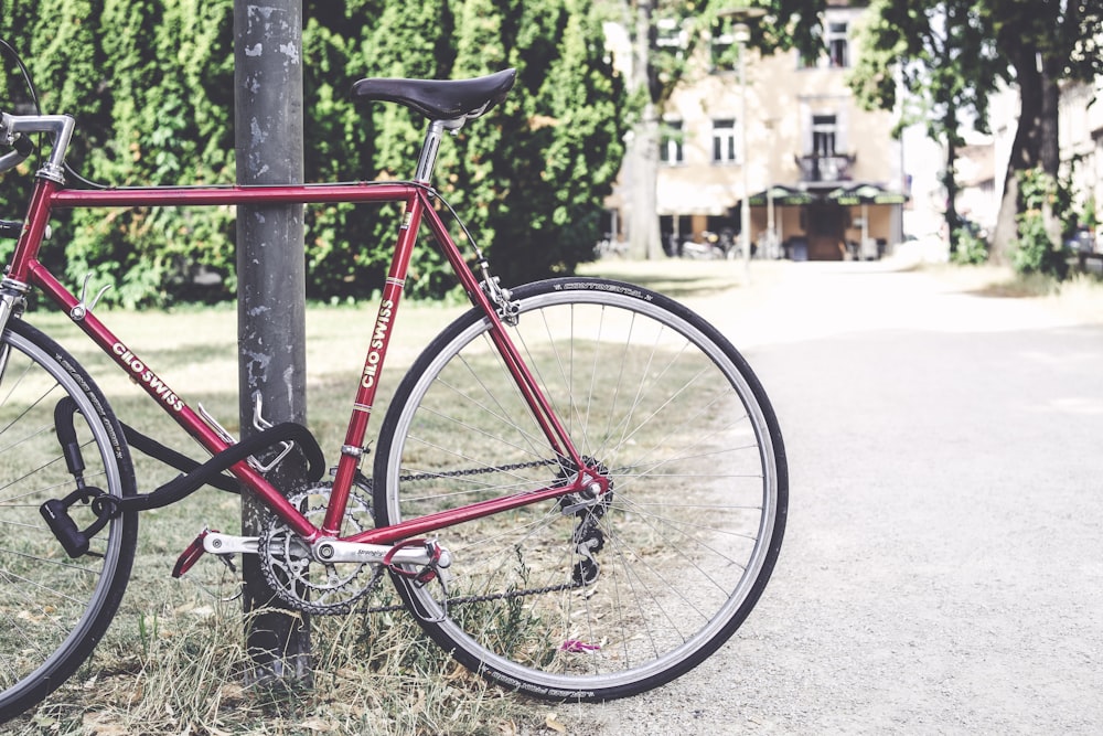 red bike parked beside post