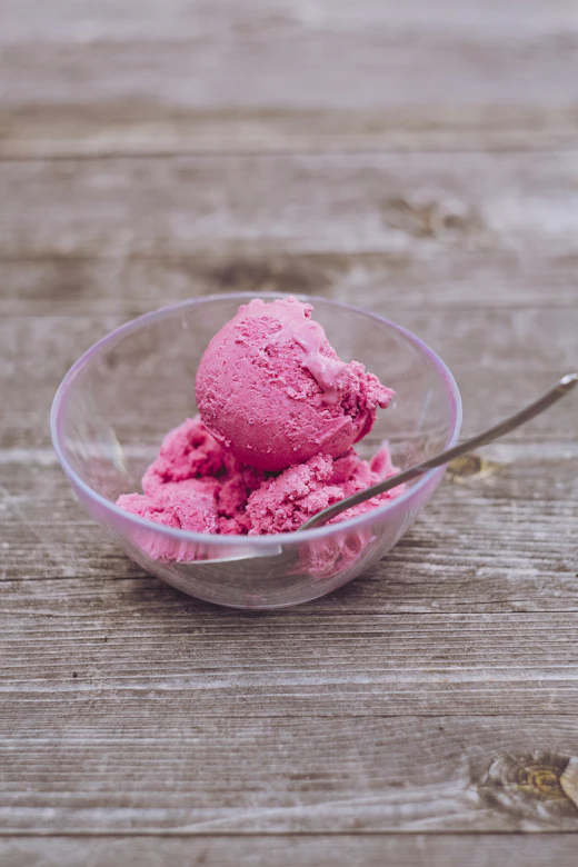 Pink berry sorbet scoops in a glass bowl