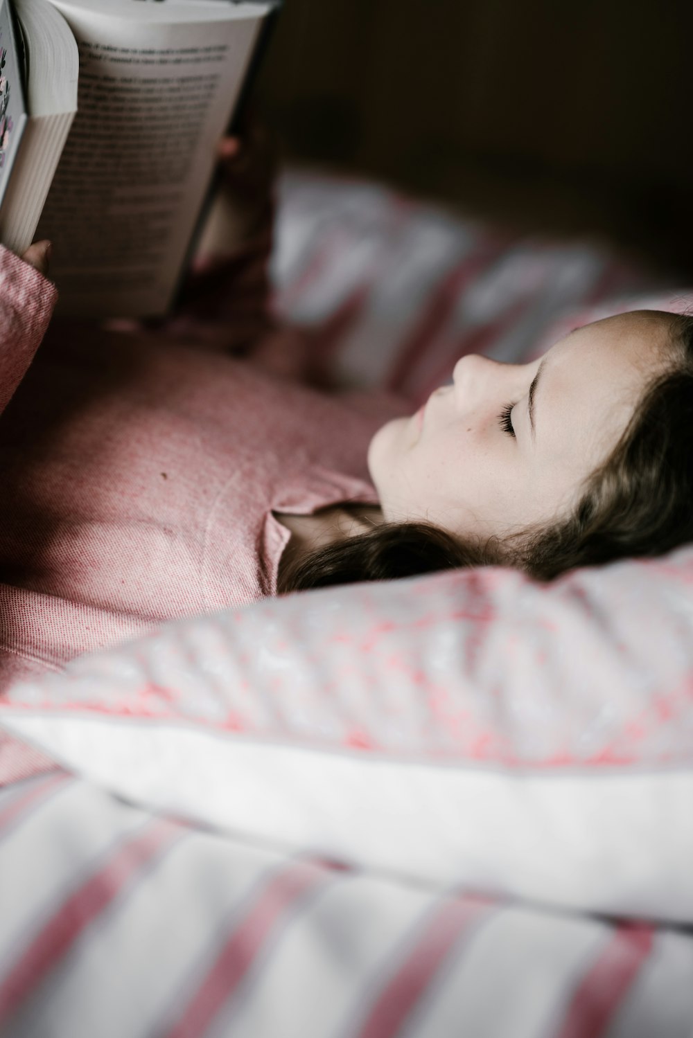 girl lying while reading book