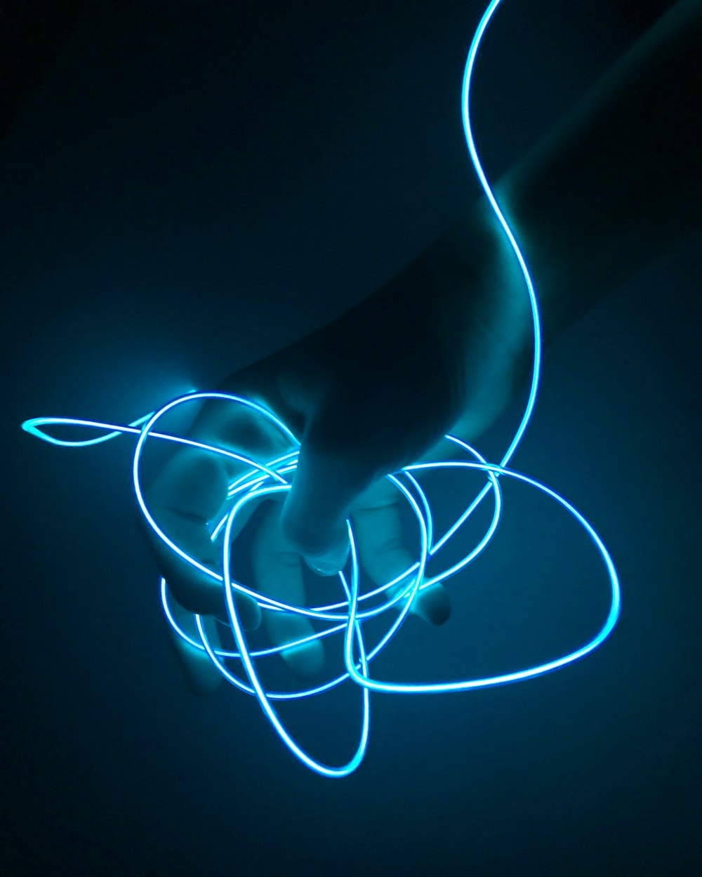 persona sosteniendo una cuerda iluminada de azul