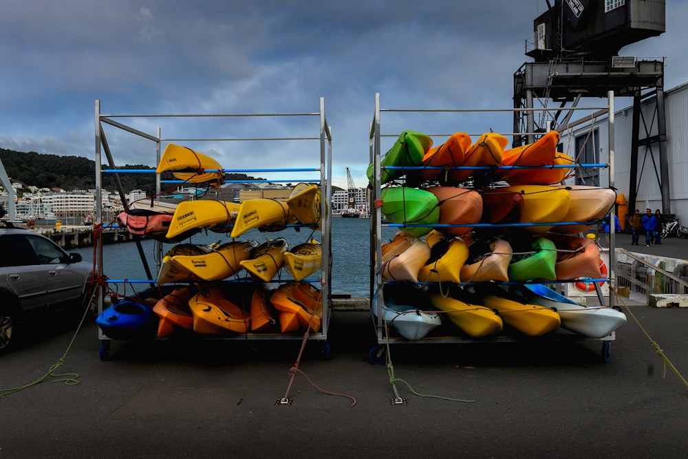 assorted-color kayak lot piled on racks