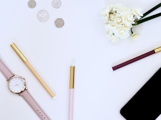 A flat lay of jewelry pieces including a watch and bangles.