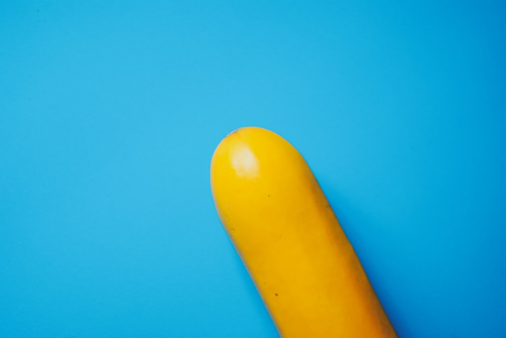 a yellow banana sitting on top of a blue surface