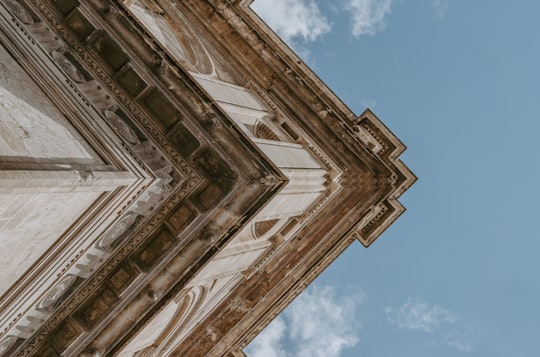 low angle photography of beige building under blue cloudy sky in Granada Spain