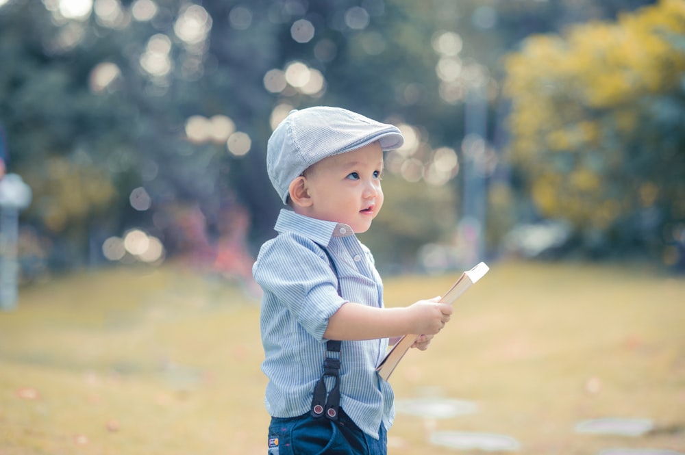 boy holding book during daytime