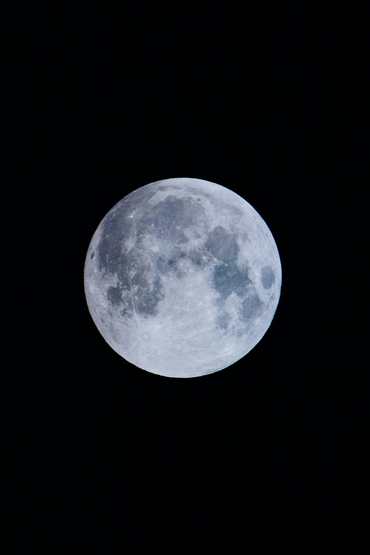 Full moon rising over a mountain range