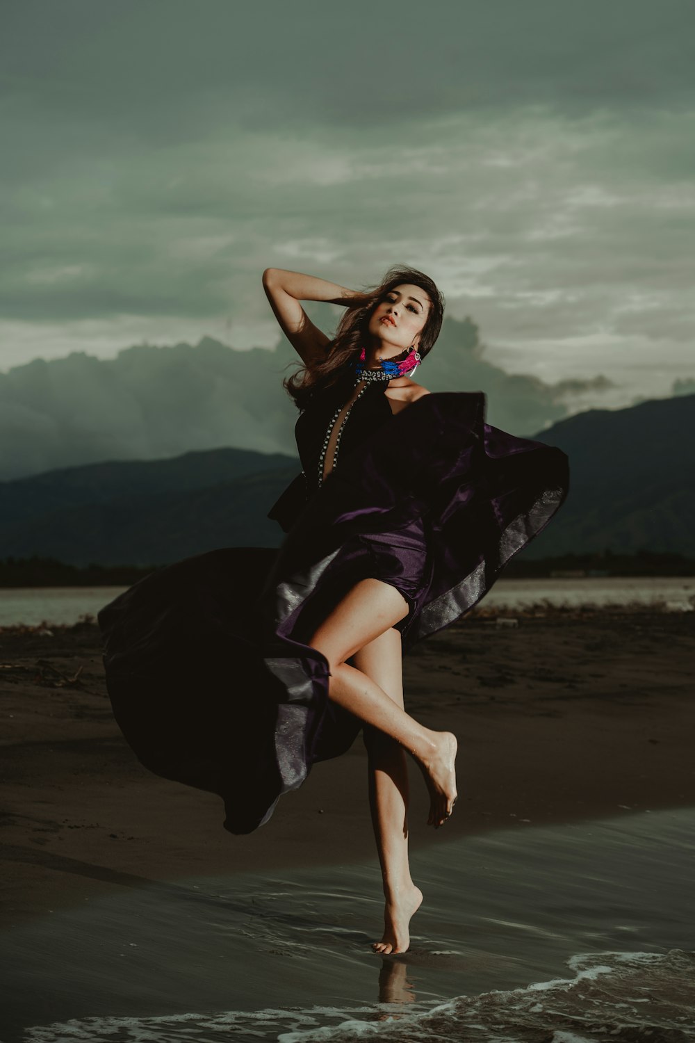 woman wearing purple dress standing on shoreline