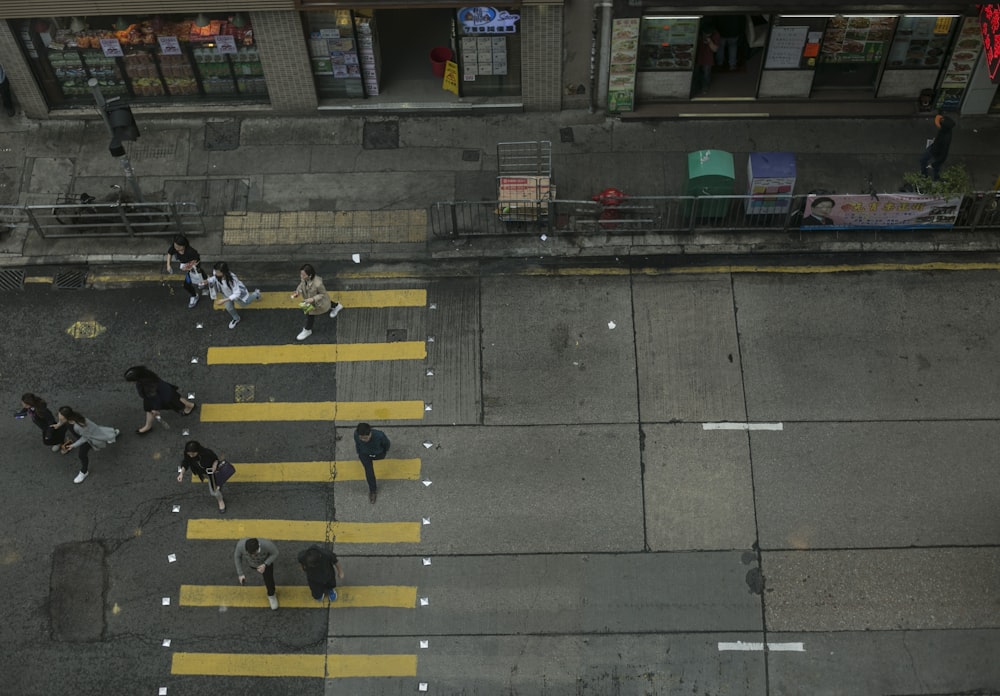 high angle photography of several people waking on concrete road