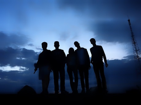 A group of diverse RPG characters standing united under a stormy sky.
