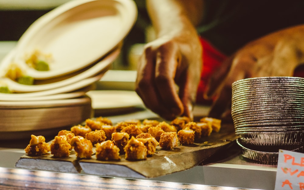 person arranging fried foods