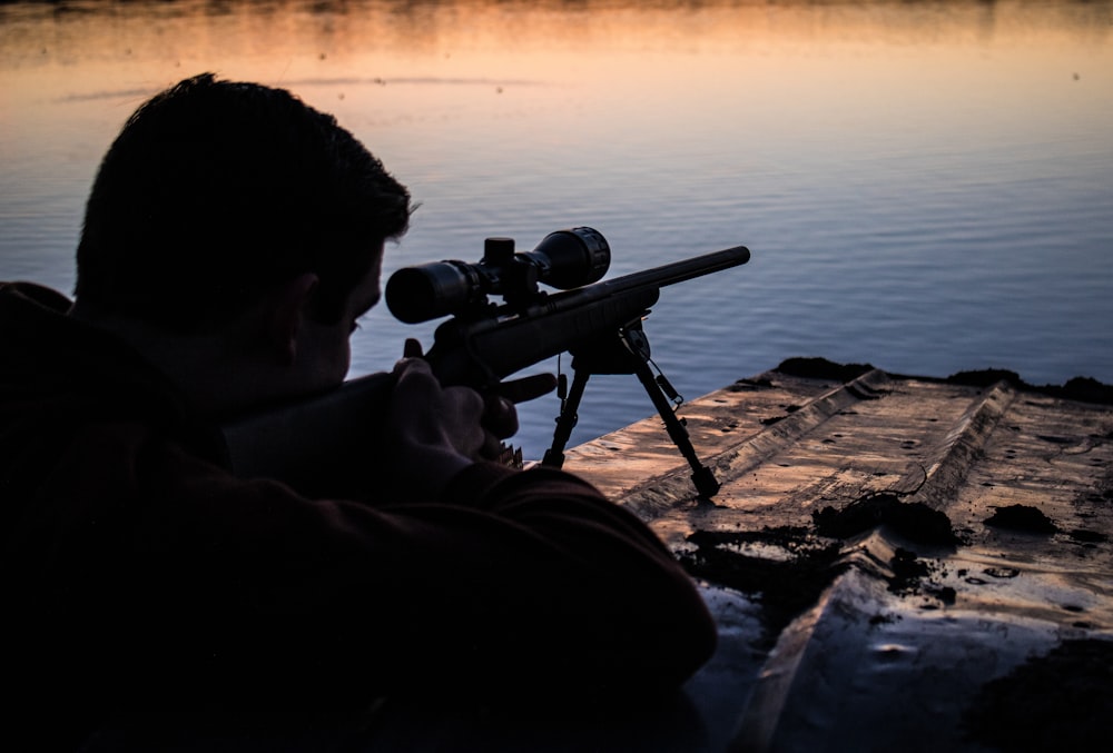 hombre apuntando rifle de francotirador al blanco