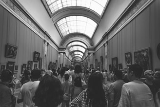group of people inside museum in grayscale photography