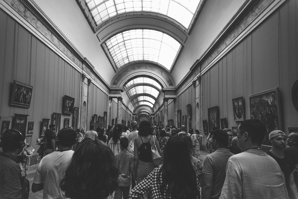 group of people inside museum in grayscale photography
