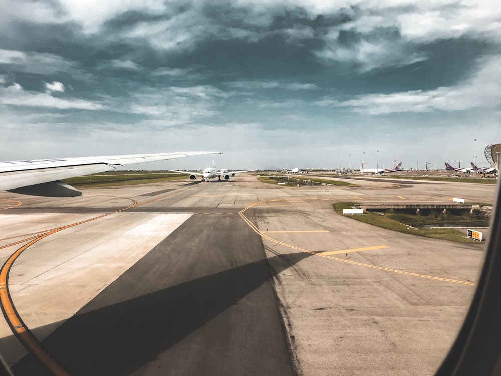 photo of white airplane on runway