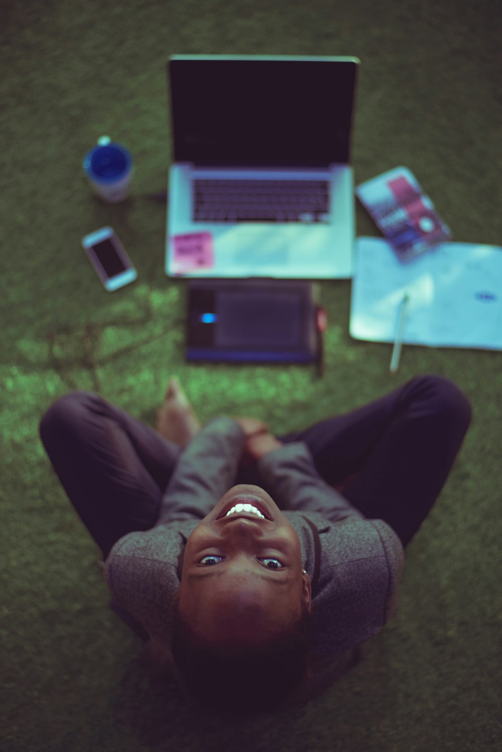 top view photo of woman sitting near MacBook Pro facing the camera