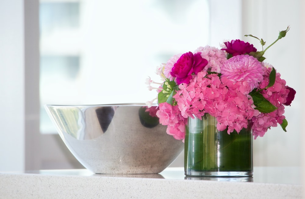 potted pink petaled flowers on table